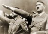 man giving a raised-arm salute at a rally