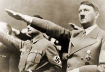 man giving a raised-arm salute at a rally