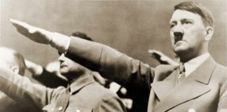 man giving a raised-arm salute at a rally