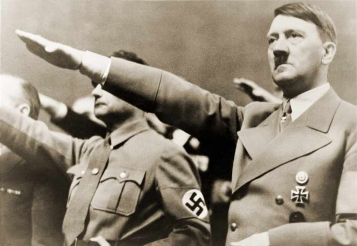 man giving a raised-arm salute at a rally