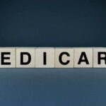 Wooden blocks spelling out MEDICARE on a dark background
