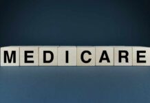 Wooden blocks spelling out MEDICARE on a dark background