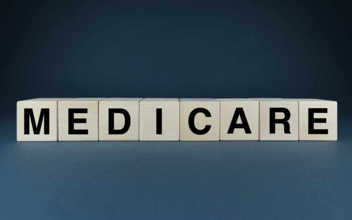 Wooden blocks spelling out MEDICARE on a dark background
