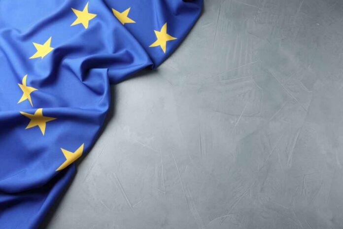 Flag,Of,European,Union,On,Grey,Table,,Above,View.,Space Soldiers in uniform facing American flag outdoors.