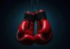 Road Rage Horror Stuns Boxing World A pair of red boxing gloves hanging against a dark background