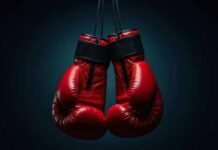 Road Rage Horror Stuns Boxing World A pair of red boxing gloves hanging against a dark background