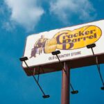 Sign for Cracker Barrel restaurant against a blue sky