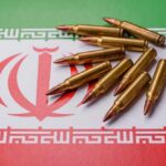 Iran Barrage STOPS Cold — Then Iraq Erupts A collection of bullets resting on the Iranian flag