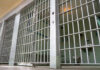 ICE Jail Death Sparks Fury Empty prison cell with metal bars and toilet.