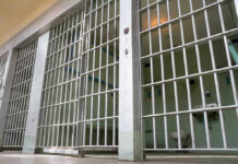 ICE Jail Death Sparks Fury Empty prison cell with metal bars and toilet.