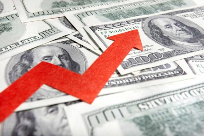 shutterstock_1122938462 A red arrow indicating growth over scattered hundred dollar bills