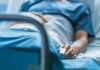 Rare Cancer, Massive Audience, Heartbreaking End A patient lying in a hospital bed with a monitoring device in hand
