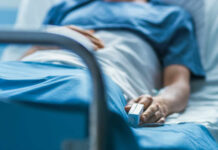 Rare Cancer, Massive Audience, Heartbreaking End A patient lying in a hospital bed with a monitoring device in hand
