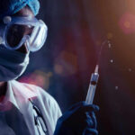 ALERT: Potassium Injections Paralyze Patients Person in PPE holding syringe with liquid droplets.