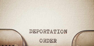 Close-up of a typewriter with the words 'DEPORTATION ORDER' typed on paper