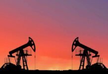 Oil pumps silhouetted against colorful sky background