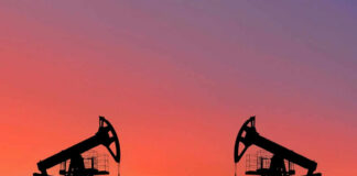 Oil pumps silhouetted against colorful sky background