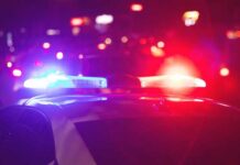 Deadly Classroom Carnage: Police Move Fast Police car with flashing red and blue lights at night