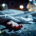 Six Dead Across Quiet Country Roads Crime scene with covered body and hand exposed.