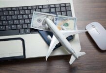 Sneaky Airfare Trick Looms A model airplane on a laptop keyboard with a passport and cash