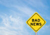 Yellow sign reads bad news in sky