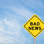 Yellow sign reads bad news in sky
