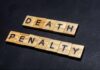 Court Drops The Hammer – DEATH! Wooden letter tiles spelling DEATH PENALTY on a dark background