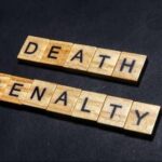 Court Drops The Hammer – DEATH! Wooden letter tiles spelling DEATH PENALTY on a dark background