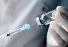 A healthcare professional preparing a syringe from a vial