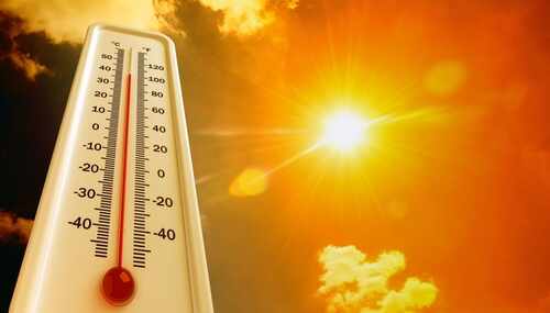 Thermometer displaying high temperature against a bright sun