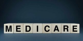 Wooden blocks spelling out MEDICARE on a dark background