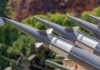 Close-up of multiple gray missiles with pointed noses and fins