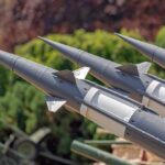 Close-up of multiple gray missiles with pointed noses and fins