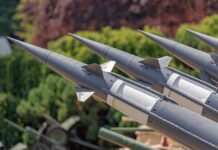 Close-up of multiple gray missiles with pointed noses and fins