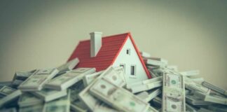 A small model house surrounded by stacks of money