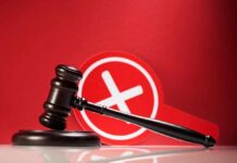 Judge Torches Maxwell: Claims Called Frivolous Judge's gavel with a red cross symbol in the background