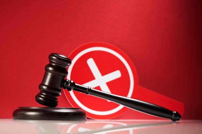 Judge's gavel with a red cross symbol in the background