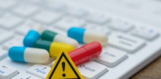 Pills and warning sign on a computer keyboard