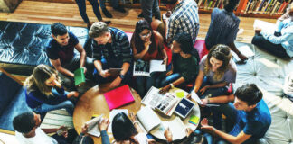 Group of young adults studying in a library.