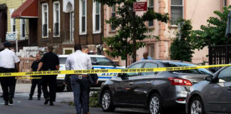 Police and crime scene tape on city street.