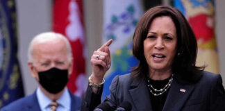 Kamala Harris speaking at podium with Joe Biden in background