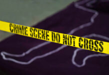 Yellow crime scene tape marking off an area with a chalk outline