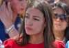 AOC’s Gambit: Three Doors, One Shot woman in red top at outdoor event