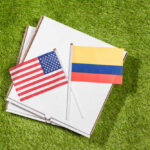 USA and Colombia flags on pizza boxes on grass