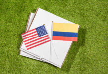 USA and Colombia flags on pizza boxes on grass
