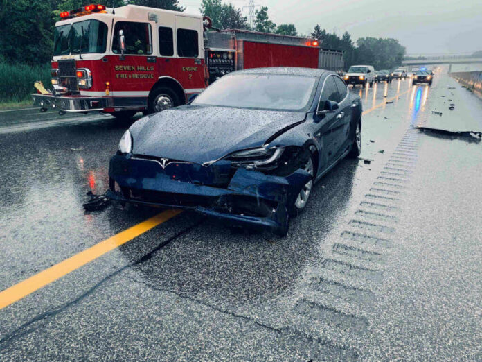 shutterstock_1478569319-1 Car crash with a Tesla on a rainy highway.