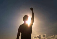 VIDEO: Principal’s Fast Act Saves 900 Kids Silhouette of person with raised fist against sunset.