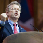 Rand Paul Freezes ICE – Trump Blinks Rand Paul speaking at a podium with a raised fist gesture