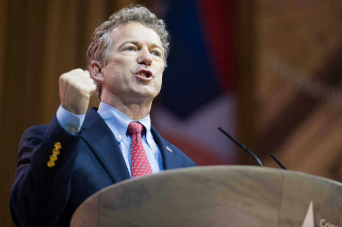 shutterstock_180495284 Rand Paul speaking at a podium with a raised fist gesture