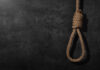 A noose made of rope hanging against a dark textured background